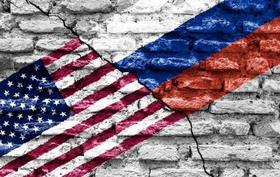 the flags of the United States and Russia painted on a ruined bricked wall and divided by a diagonal crack. International diplomatic relations.