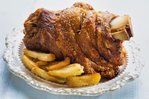 close up of rustic german golden baked pork knuckle