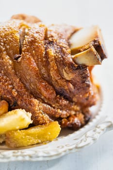 close up of rustic german golden baked pork knuckle