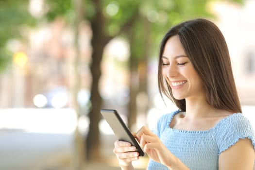 Asian woman using smart phone walking in the street