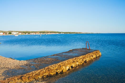 Old stone mole and blue sea in city Vir, Croatia. Nice view of the blue Adriatic sea during a sunny day.