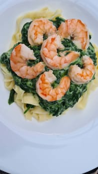 Shrimp Fetticcin Pasta. Italian pasta with shrimp and cream Alfredo sauce, top view, copy space.
