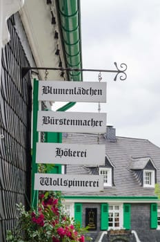 Slate house facade in a historic old town. Advertising signs at the house, can be labeled.