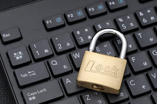 KAGAWA, JAPAN - FEBRUARY 20, 2022 - Padlock on computer keyboard. Concept of Internet security, data protection.