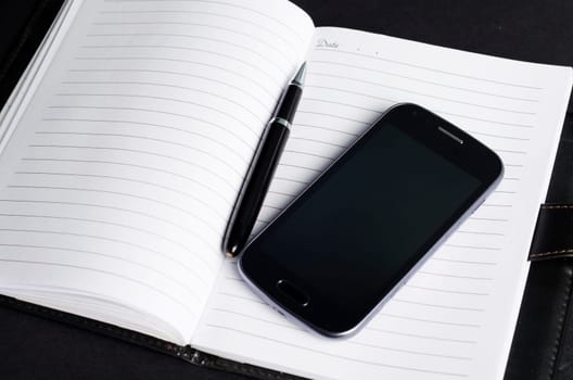 Mobile phone and open notebook