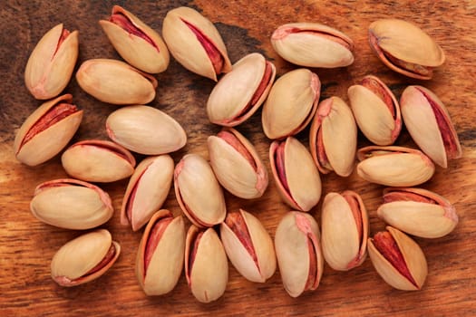 Table top view - turkish red roasted pistachios on wood board.