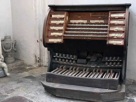 The vintage and dusty piano in traditional wood with pedals