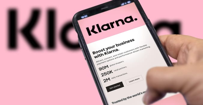 Rome, Italy, February 2022: Hand holding a device with the Klarna mobile app on the screen. Klarna is the largest private fin-tech start-up in Europe, founded by the bank of the same name. Illustrative editorial