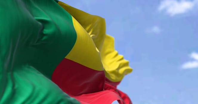 Detail of the national flag of Benin waving in the wind on a clear day. Benin is a country in West Africa. Selective focus.