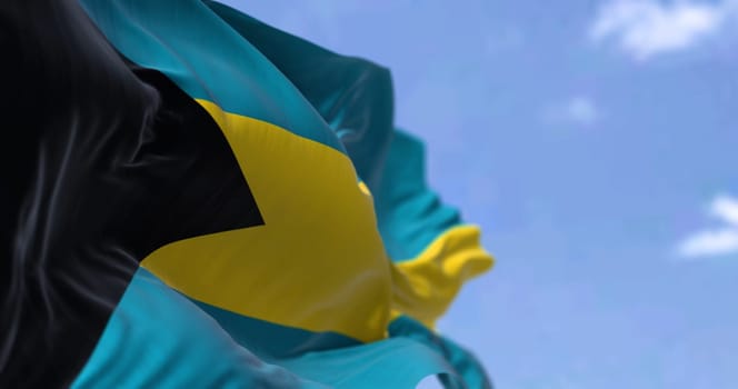 Detail of the national flag of the Bahamas waving in the wind on a clear day. Bahamas is a sovereign country within the Lucayan Archipelago of the West Indies in the Atlantic. Selective focus.