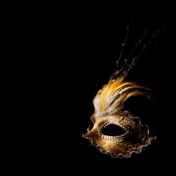 Golden venetian mask over black background