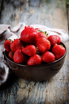 Strawberries in bowl on rustic table