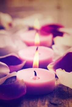Spa candles and rose petals. Retro filter.
