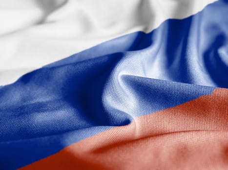 Close up of the Russia flag on a ruffled mesh fabric. Curves and folds of the satin fabric with texture. Selective focus and depth of field. Democracy and politics.