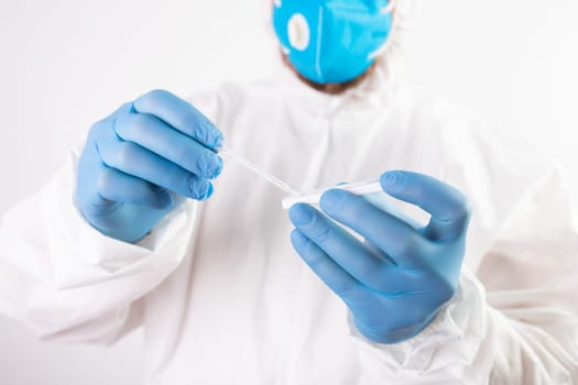 Medical healthcare holding COVID-19, coronavirus swab collection kit, wearing protective suit
