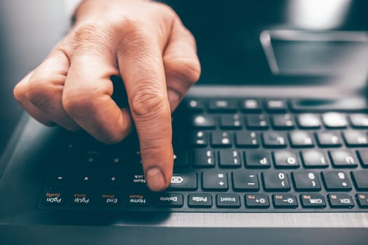 Close up of business man hand working on laptop computer on wooden desk as concept