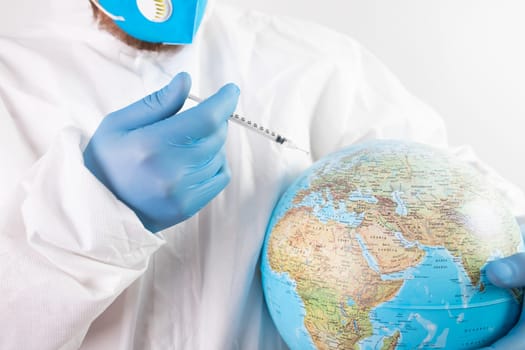 Pandemic concept, close up of scientist injecitng vaccine into the earth. Concept fight against virus.