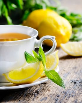 Cup of tea with mint and lemon slices.