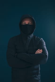 Scary man hiding in the shadows, with the face and identity hidden with the hood. Concept for fear, mystery, danger, crime, stalker