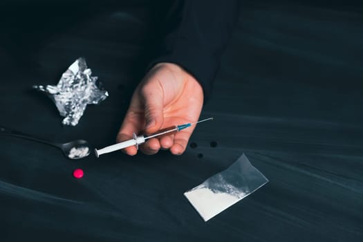 Drug addict reaches for another dose of drug. Concept of addiction, antidrug. International Day against Drug Abuse.