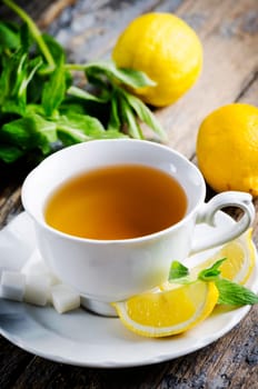 Cup of tea with mint and lemon slices.