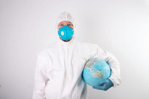 World epidemic danger concept. Male doctor man in medical face mask and gloves protecting planet Earth.