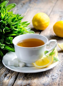 Cup of tea with mint and lemon slices.