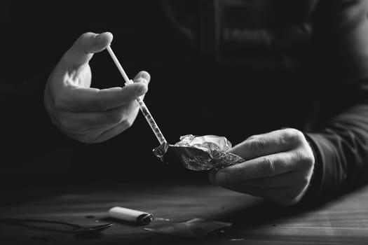 Addict/junkie man preparing drugs. The concept of crime and drug addiction.