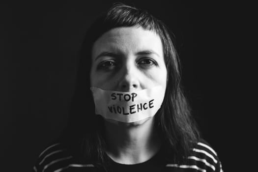 Women violence and abused concept. Stop domestic violence against women and human trafficking.Woman with tape on mouth and stop violence text