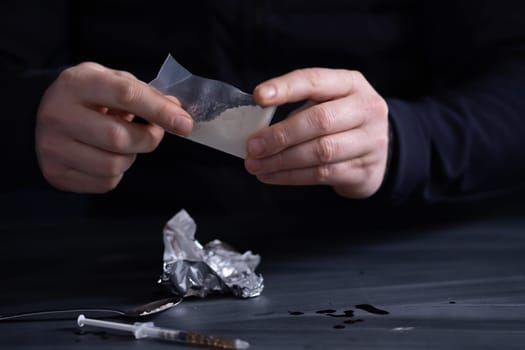 Addict/junkie man preparing drugs. The concept of crime and drug addiction.