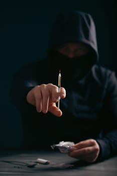 Addict/junkie man preparing drugs. The concept of crime and drug addiction.