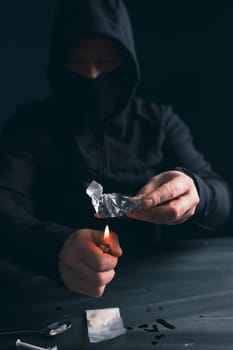 Addict/junkie man preparing drugs. The concept of crime and drug addiction.