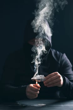Addict/junkie man preparing drugs. The concept of crime and drug addiction.