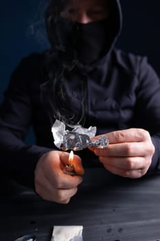 Addict/junkie man preparing drugs. The concept of crime and drug addiction.