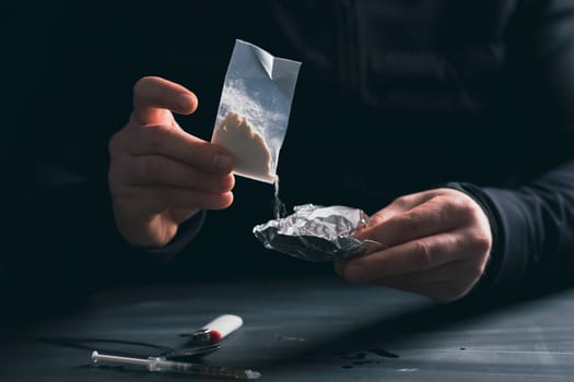 Addict/junkie man preparing drugs. The concept of crime and drug addiction.