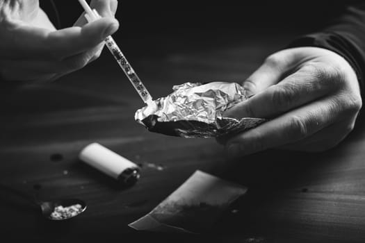 Addict/junkie man preparing drugs. The concept of crime and drug addiction.