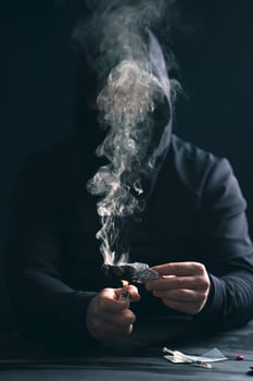 Addict/junkie man preparing drugs. The concept of crime and drug addiction.