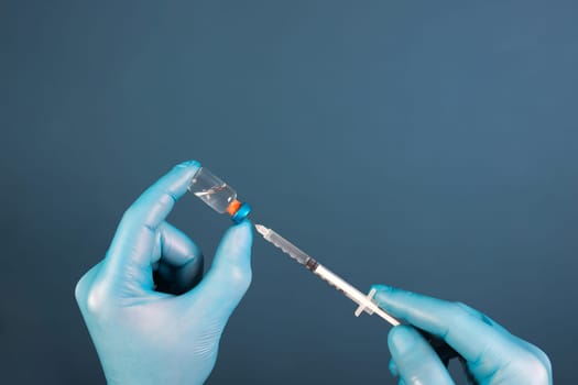 COVID-19 coronavirus vaccine. Vaccination concept. Doctor's hand in blue gloves hold medicine vaccine vial bottle and syringe.