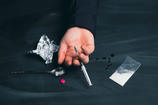 Drug addict reaches for another dose of drug. Concept of addiction, antidrug. International Day against Drug Abuse.