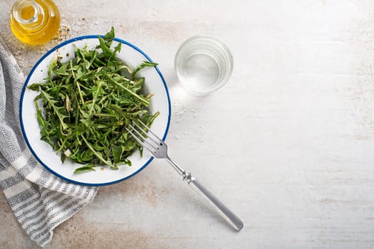 Fresh dandelion salad with dressing. Healthy spring food meal