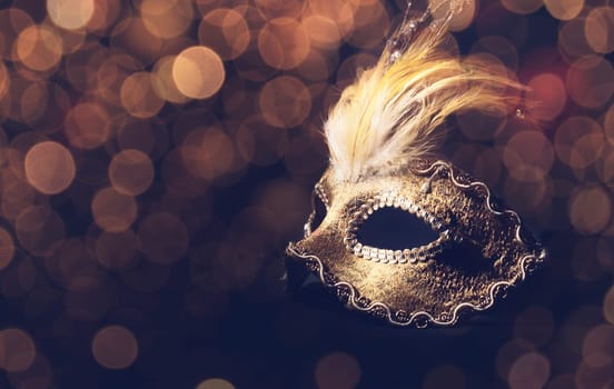 Golden venetian mask over black background