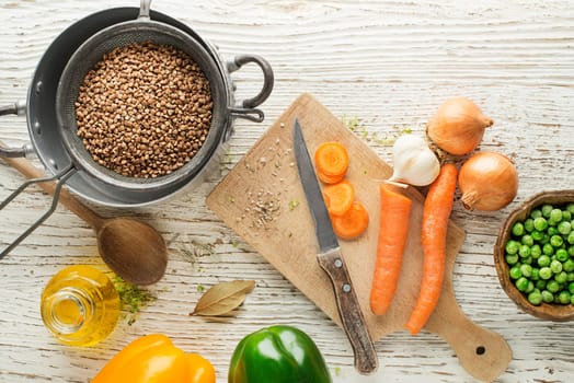 Ingredients for cooking fresh buckwheat porridge meal on wooden background