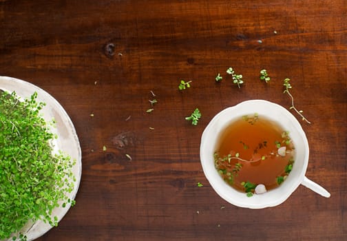 Tea Cup of fresh herbal leaves on wooden background, top view, place for text. Healthy concept
