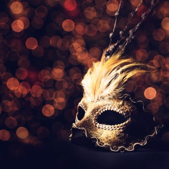 Golden venetian mask over black background