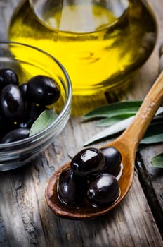 Olives and olive oil on wooden table