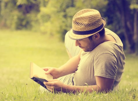 Man reading a book on the grass