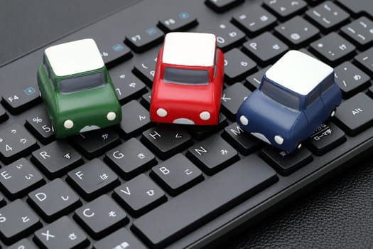 KAGAWA, JAPAN - FEBRUARY 23, 2022 - Small toy car on Alphabetics and Japanese hiragana typing keyboard.
