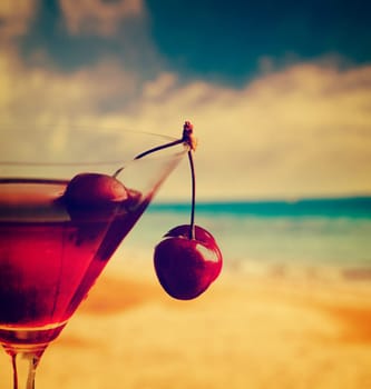 Cherry cocktail on the beach in retro style