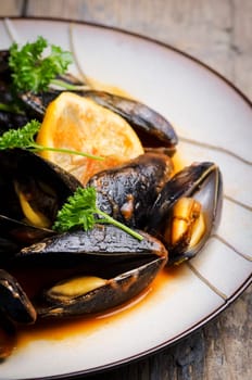 Mussels in tomato sauce on rustic wooden table