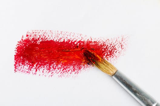 Red paint brush on white paper
